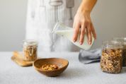 buehne-laktoseintoleranz frau schuettet milch in schuessel